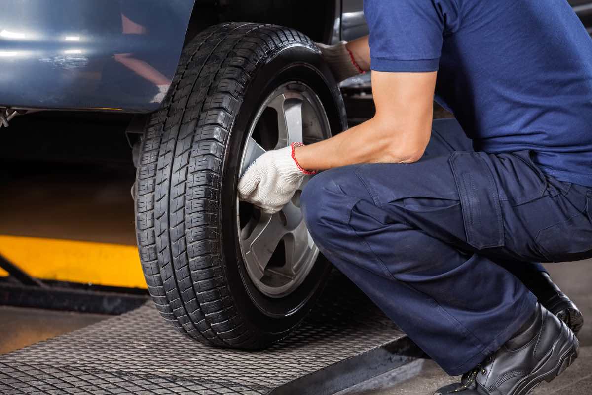 Low section of mechanic fixing car tire at auto repair shop