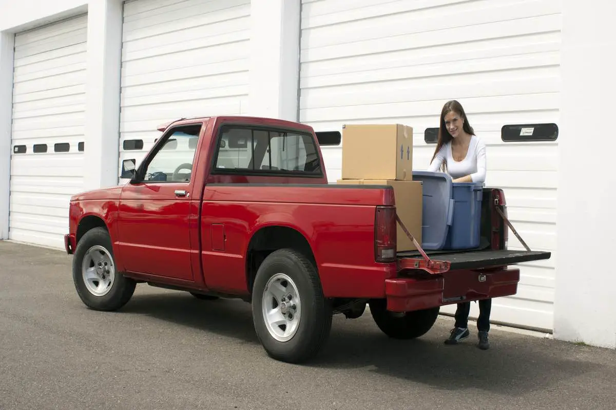 Woman gets out of truck to unload at storage location
